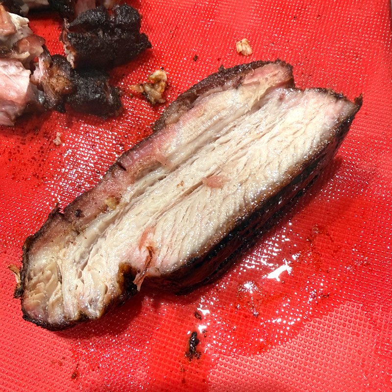 Thick slice of smoked pork belly with smoke ring